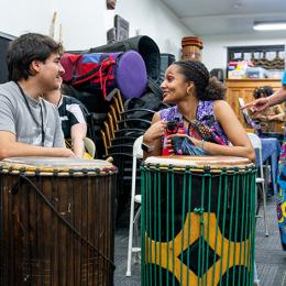 Students chat over a pair of drums
