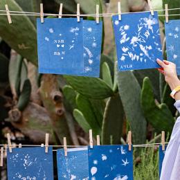 image of a woman looking at blue artworks hanging on a clothes line